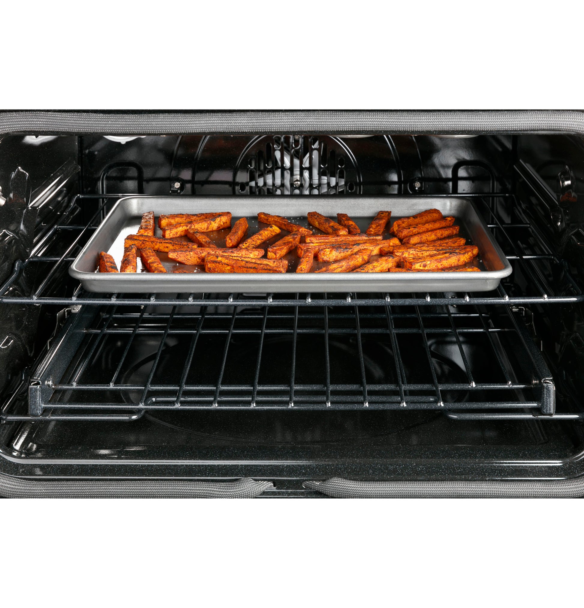Tray of seasoned fries baking inside a stainless steel dual-fuel range oven from kitchen appliances collection