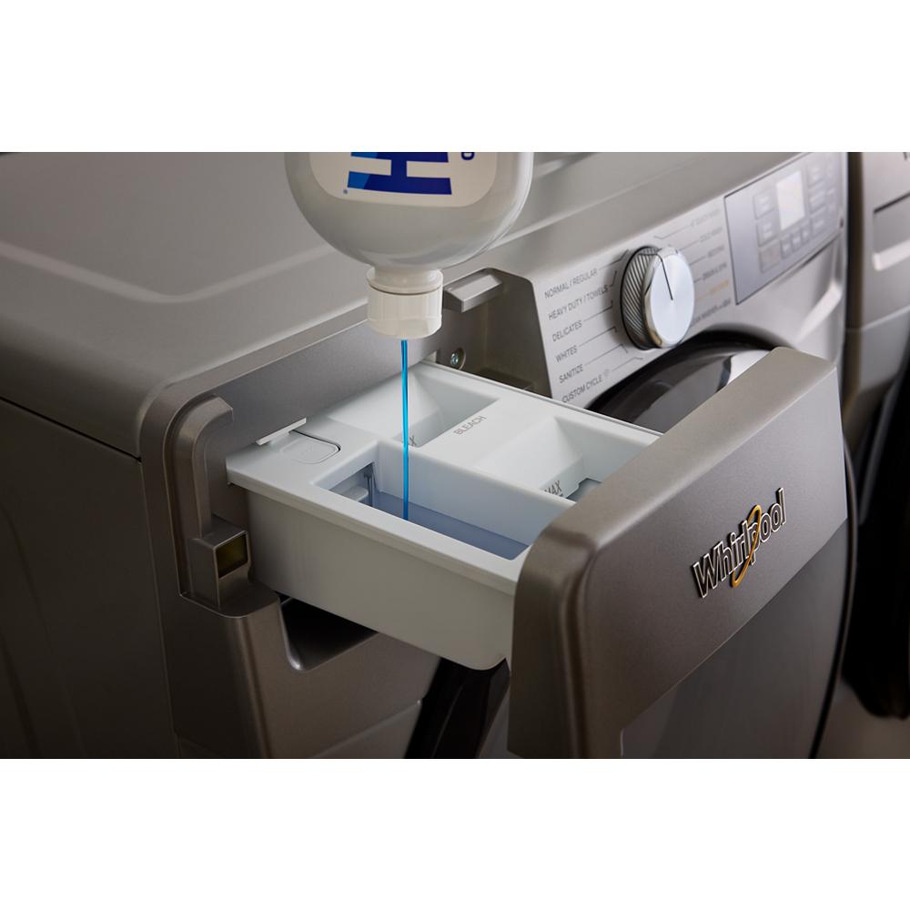 Detergent being poured into the detergent compartment of a silver front load washer in home improvement setting.
