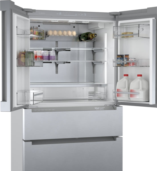 Open stainless steel French door refrigerator with bottom freezer showing adjustable glass shelves and door bins in Bosch appliances collection