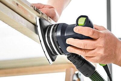 Electric delta sander with dust collection attachment sanding wood trim for home improvement projects