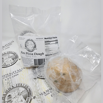 Clear plastic bag of spicy pizza dough with nutritional label, placed on branded wrapping for grilling and outdoor cooking use