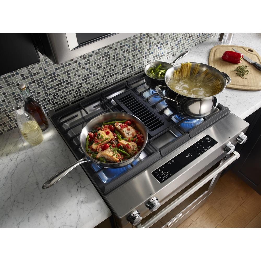 KitchenAid 30-inch dual fuel range with four burners cooking chicken and pasta in stainless steel pots on gas cooktop