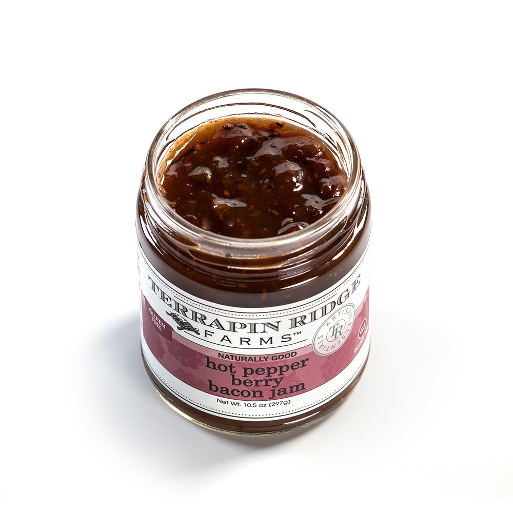 Open jar of spicy berry and bacon jam with visible chunks in food and beverage collection