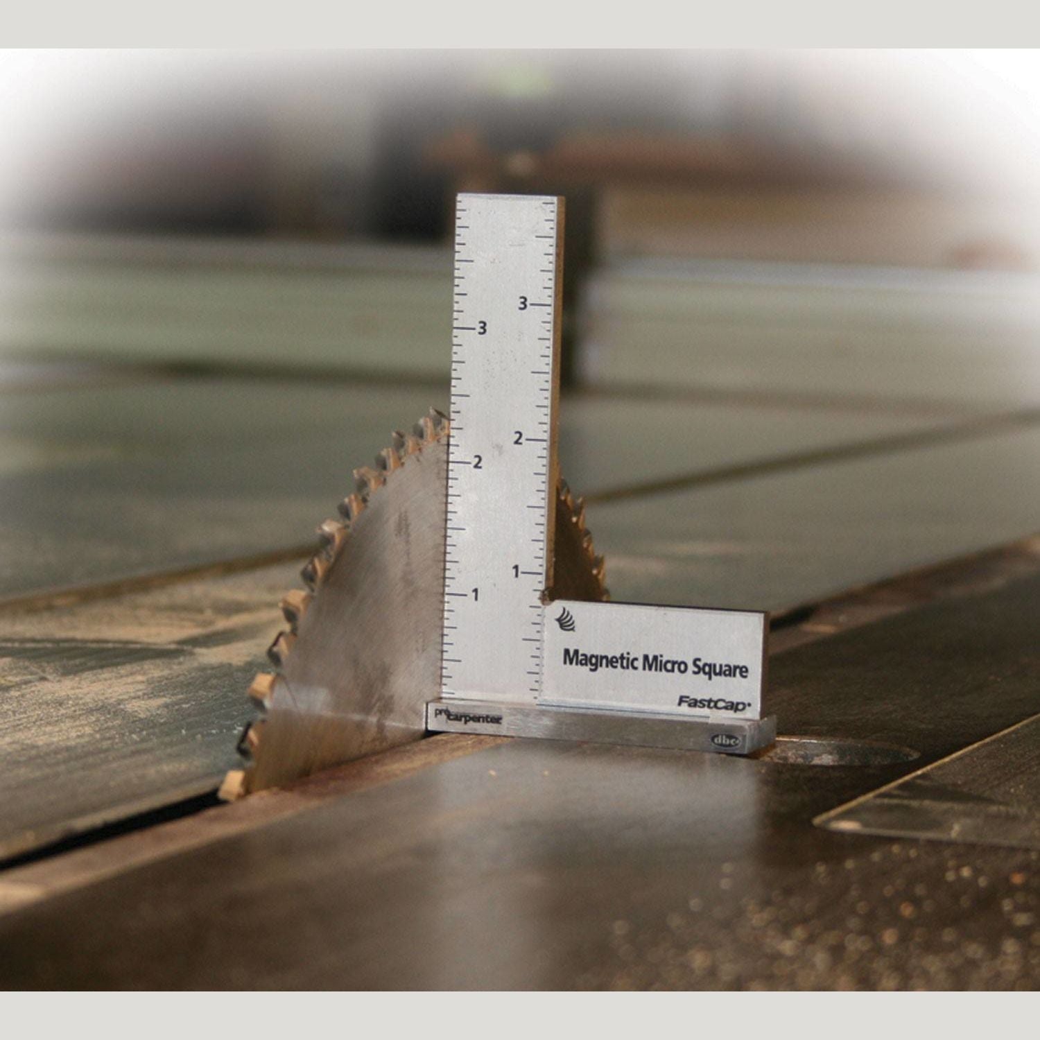 Small magnetic square tool measuring precision alignment on wood table saw blade for woodworking and hand tools