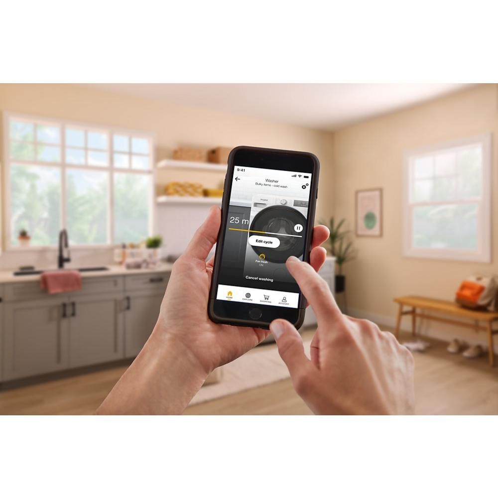 Person using a smartphone app to remotely control a smart dryer in a bright, modern laundry room setting