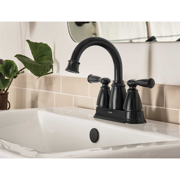 Matte black two-handle high arc bathroom faucet installed on white sink in bathroom and home improvement setting