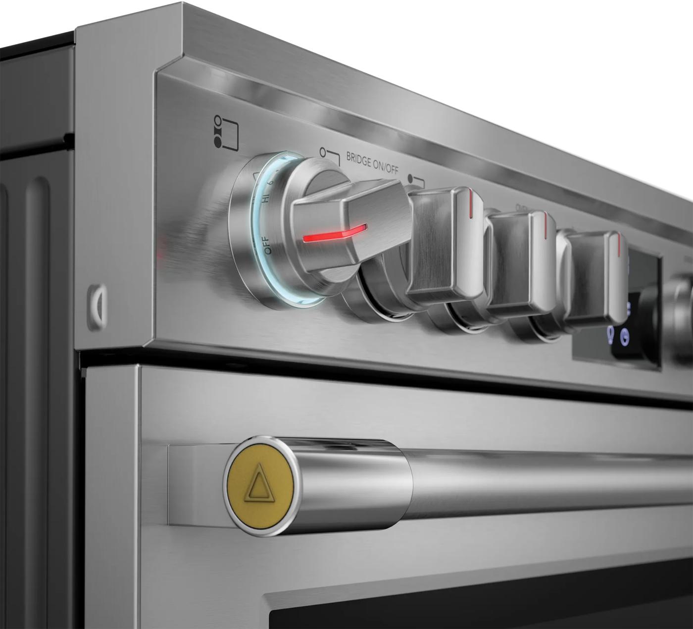 close-up of stainless steel electric range front control knobs with illuminated setting in kitchen appliances collection