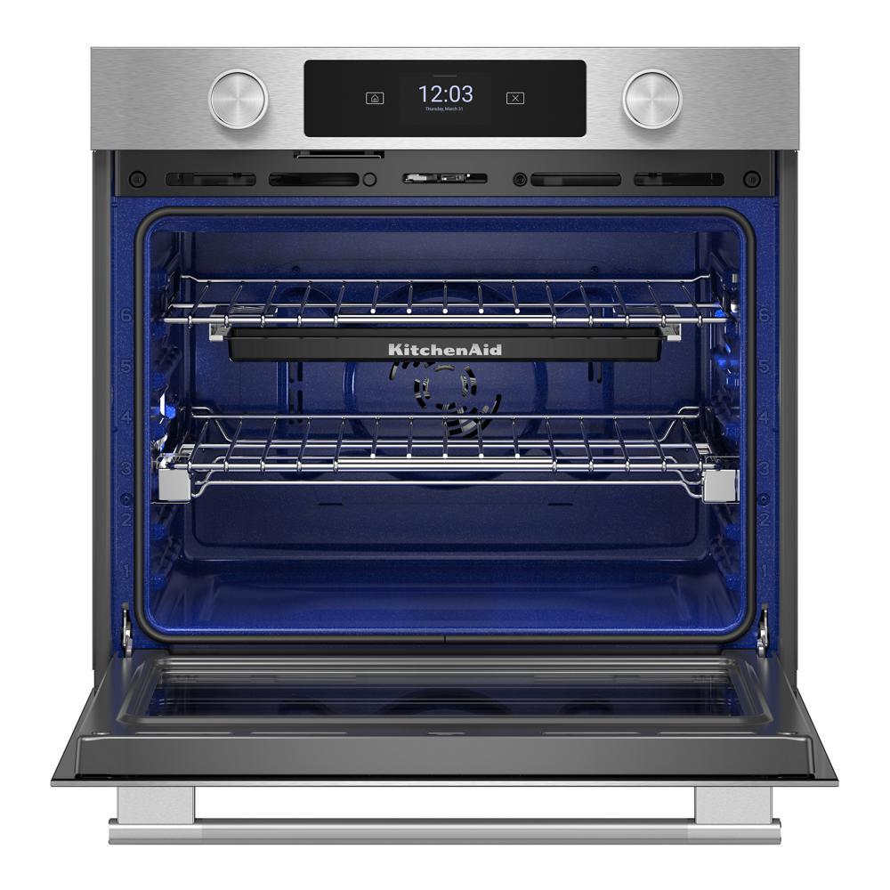 Open stainless steel smart electric wall oven with LED display and blue interior from KitchenAid appliances collection