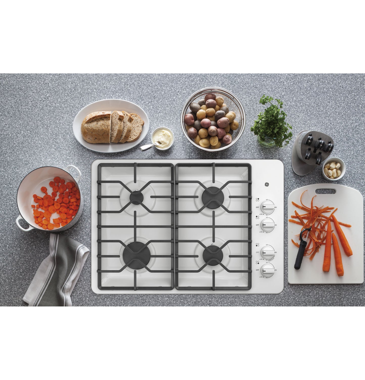White built-in gas cooktop with four burners, dishwasher-safe grates, and control knobs on the right in Kitchen & Cooktops collections