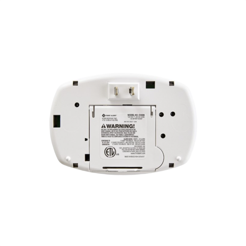 Back view of white plug-in carbon monoxide alarm with battery backup and warning label for home safety use