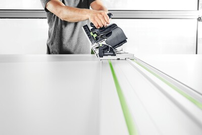 Person using a Festool plunge cut track saw with guide rail for smooth, precise cuts in home improvement power tools collection