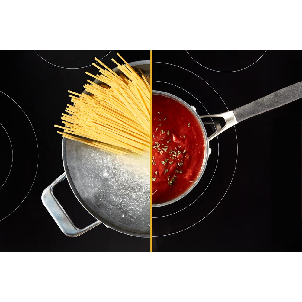 Overhead view of a stainless steel pot boiling water with spaghetti on one side and a saucepan with simmering tomato sauce on an electric range cooktop, ideal for kitchenware and appliances collections.