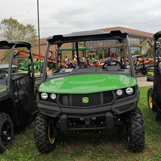 Green full-size crossover utility vehicle with rugged tires and front grill for outdoor and home improvement use