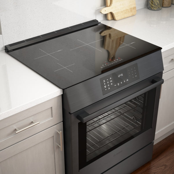 Black stainless steel 30-inch induction slide-in range with digital touch controls and glass oven door in modern kitchen setting