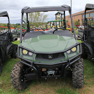 Green mid-size crossover utility vehicle with front brush guard and rugged off-road tires for outdoor use