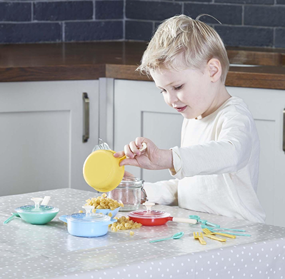 Young child playing with colorful miniature pots, pans, and utensils for pretend cooking and imaginative play