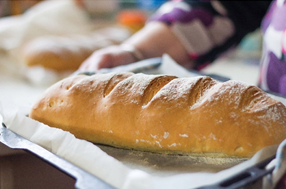Freshly scored artisan bread loaf resting on parchment paper in kitchenware and bakeware collections under $50