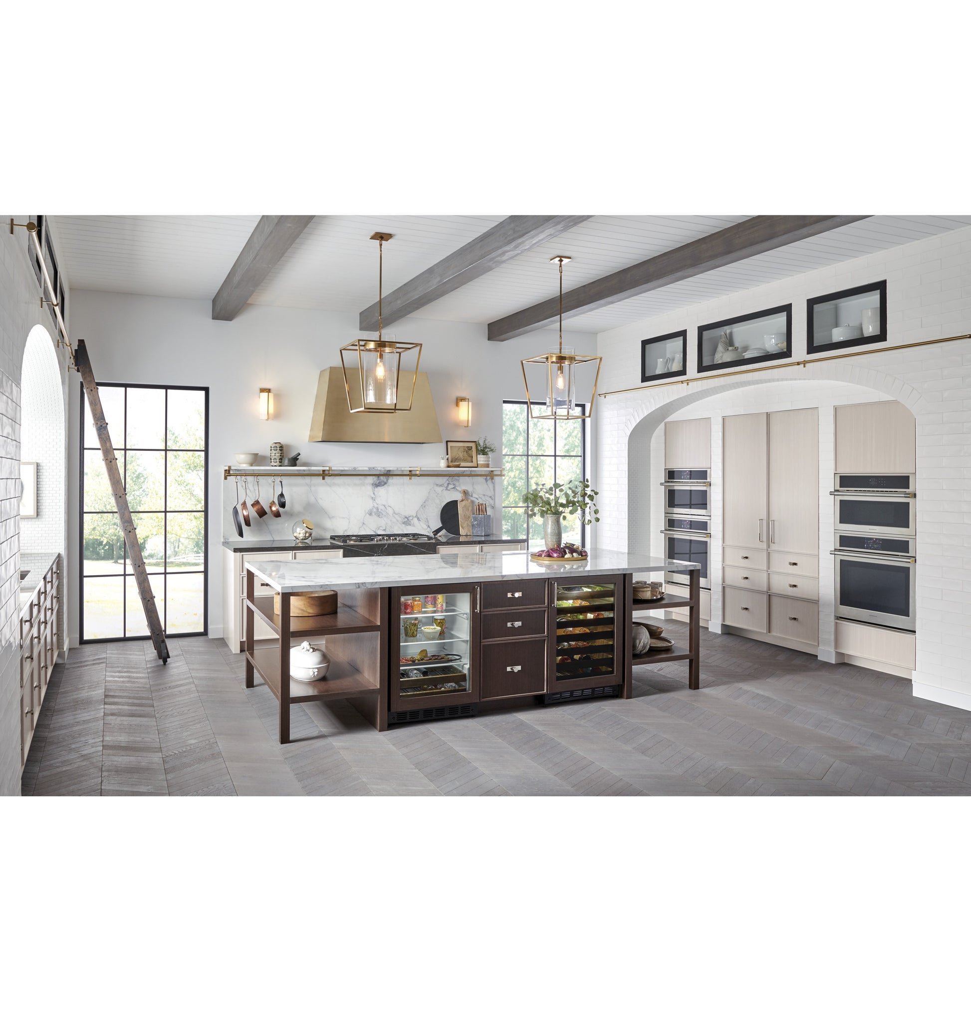 Spacious kitchen with island featuring wine cooler and built-in single wall ovens in modern appliances collection