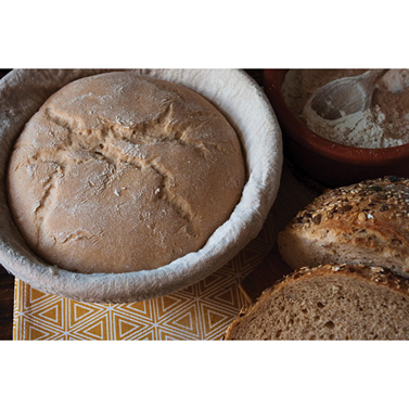 Round proofing basket with linen liner holding dough for artisan bread rising in kitchenware and home baking collection