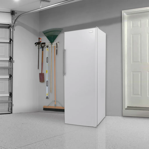 White vertical freezer with stainless steel handle in a garage setting from Freezers & Ice Makers collection