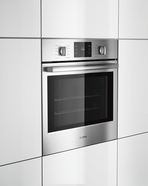 Built-in stainless steel single wall oven with metal knobs and digital display in modern kitchen cabinetry