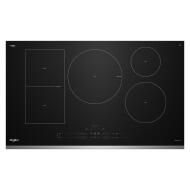Black induction cooktop with four cooking zones and digital touch controls in modern kitchen appliances setting
