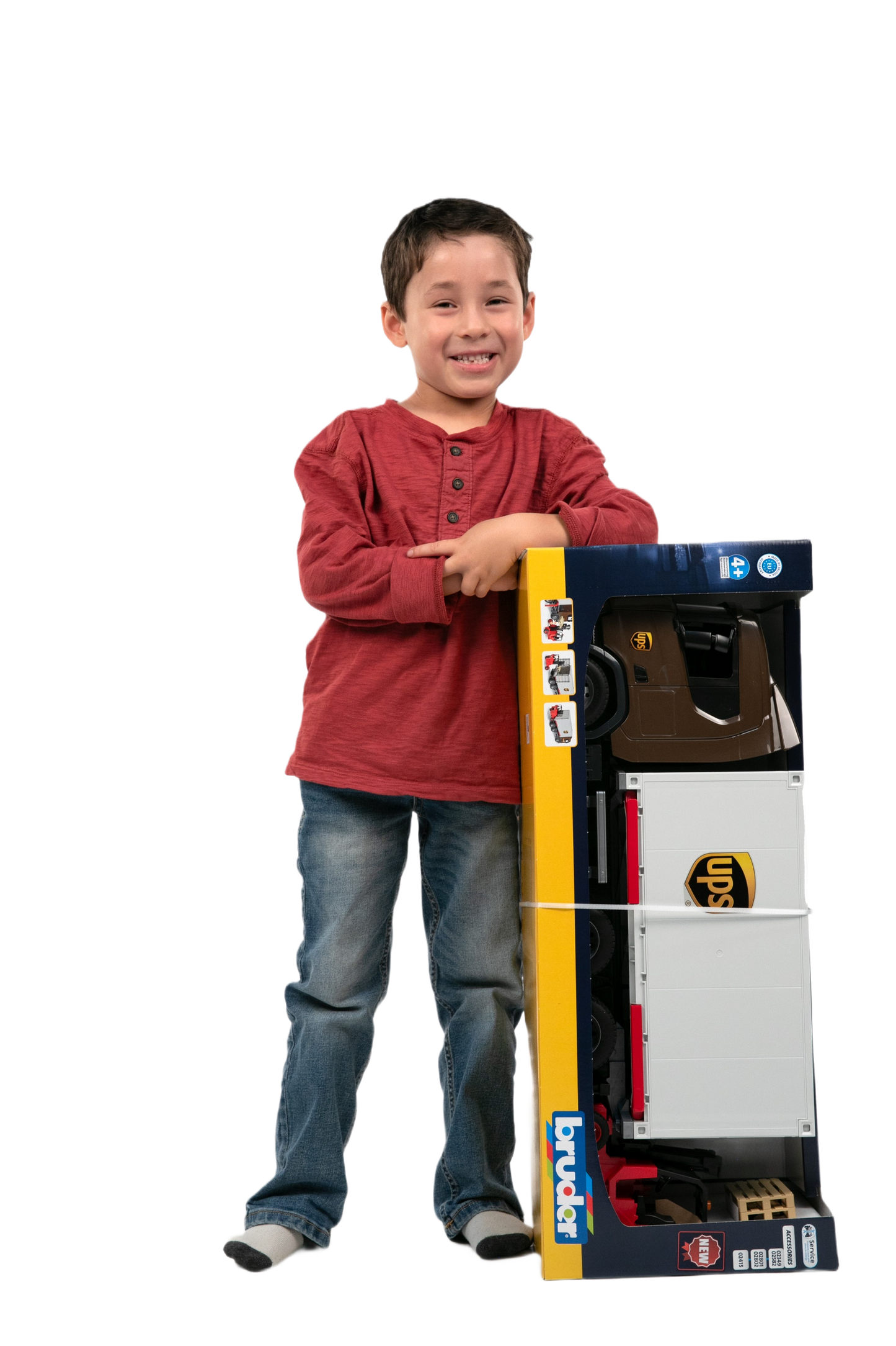 Young boy smiling and holding boxed Bruder Scania Super 560R UPS logistics toy truck in Vehicles & Remote Controlled Toys collection