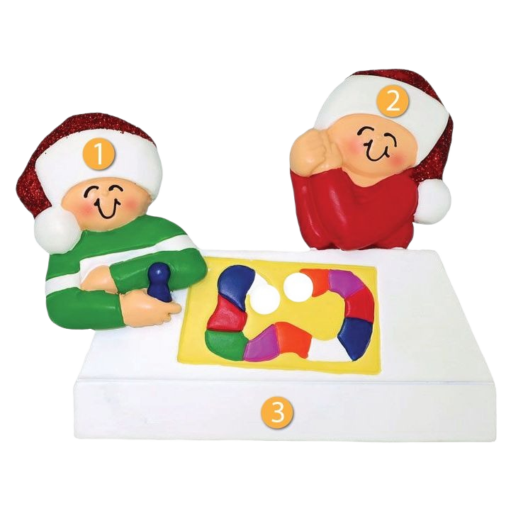 Christmas ornament featuring two joyful figures in festive hats playing a colorful board game decoration