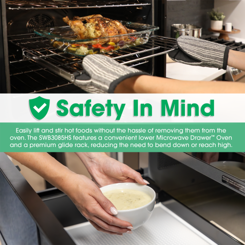 Hands with oven mitts removing roasted chicken from open convection oven above microwave drawer with bowl inside drawer