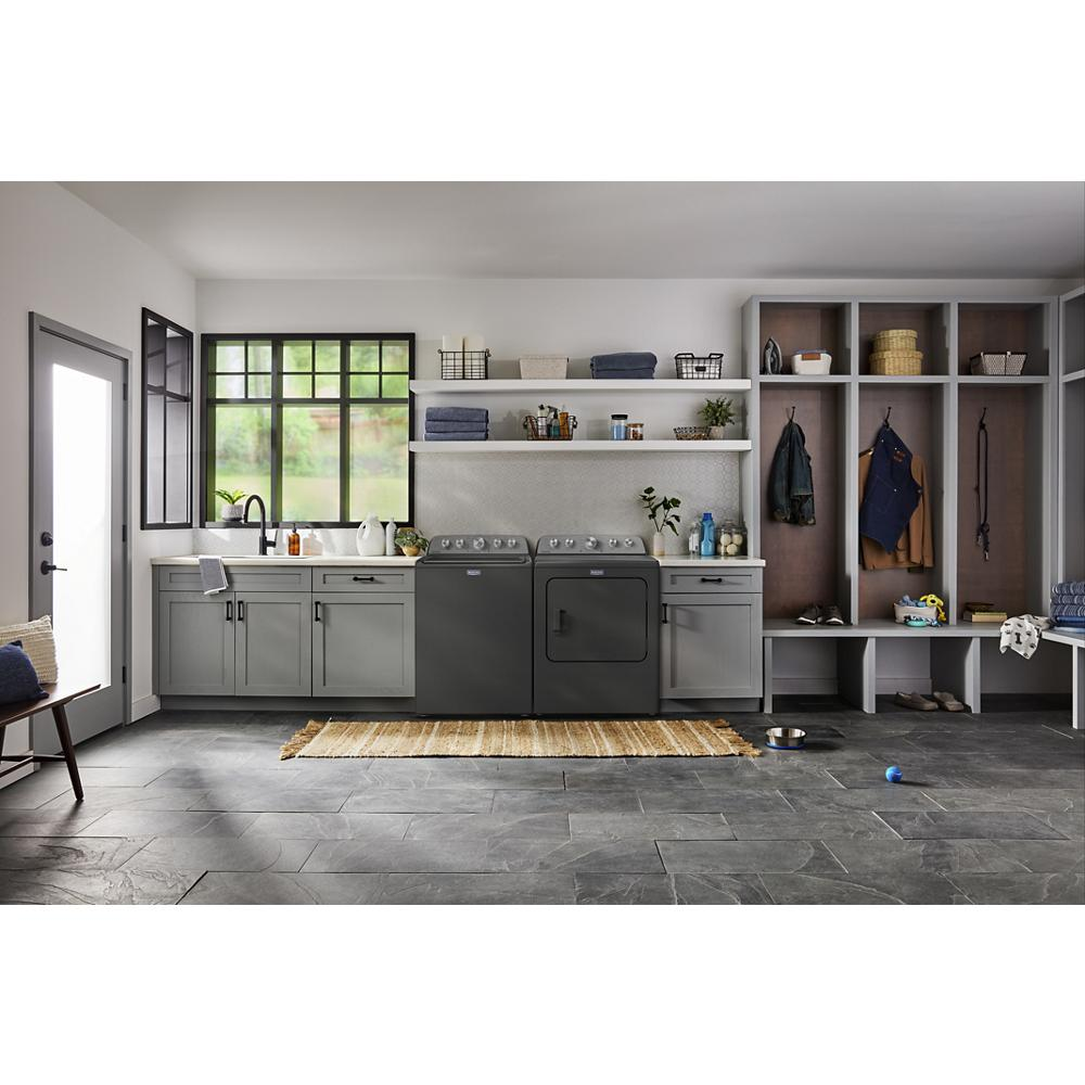 Laundry room with gray cabinetry, black top load washer and dryer, open shelving, and organized storage cubbies with seating bench