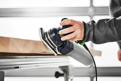 Person using a Festool sander with attached long life dust collection bag for a home improvement project