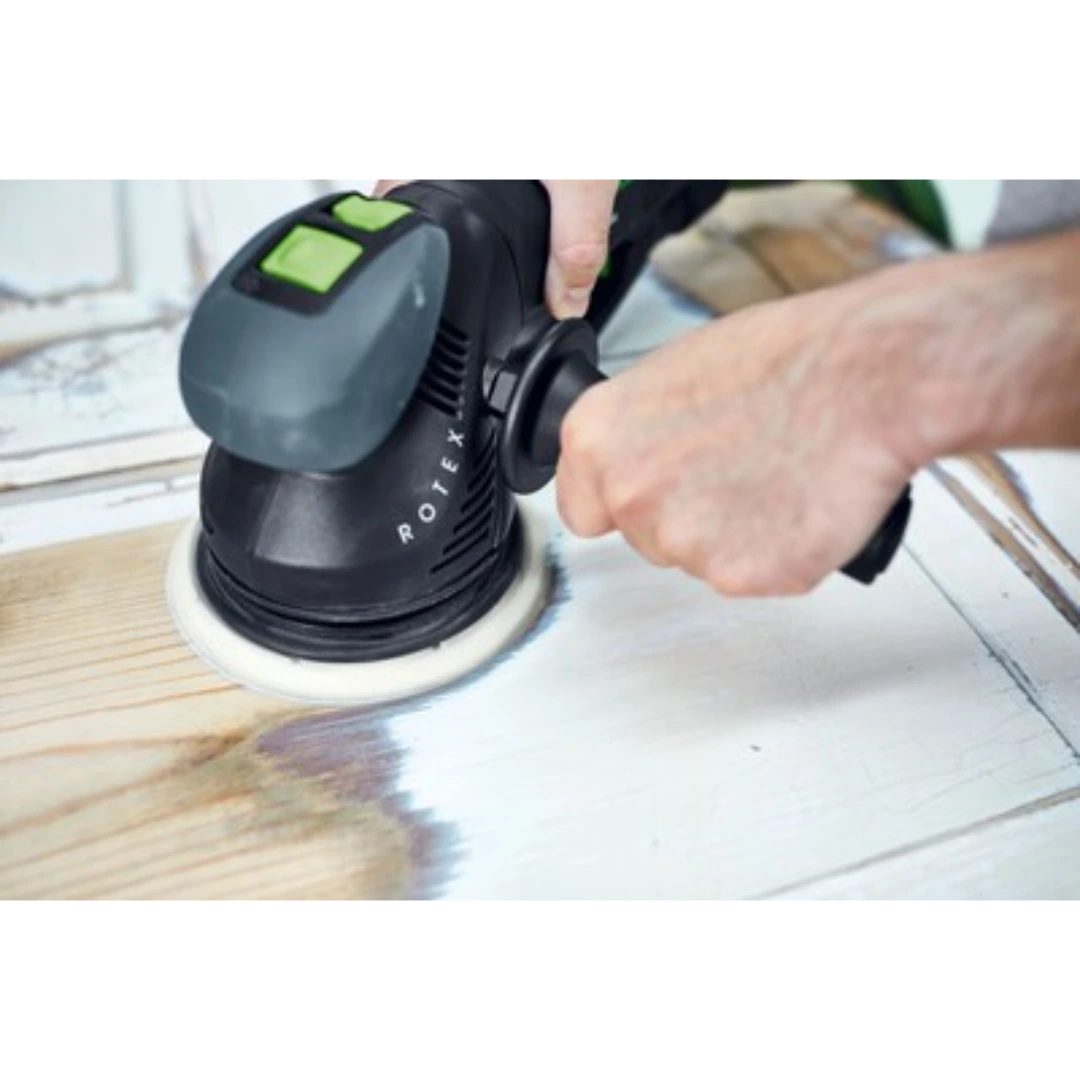Person using black handheld rotary sander with auxiliary handle on wood surface for home improvement tasks
