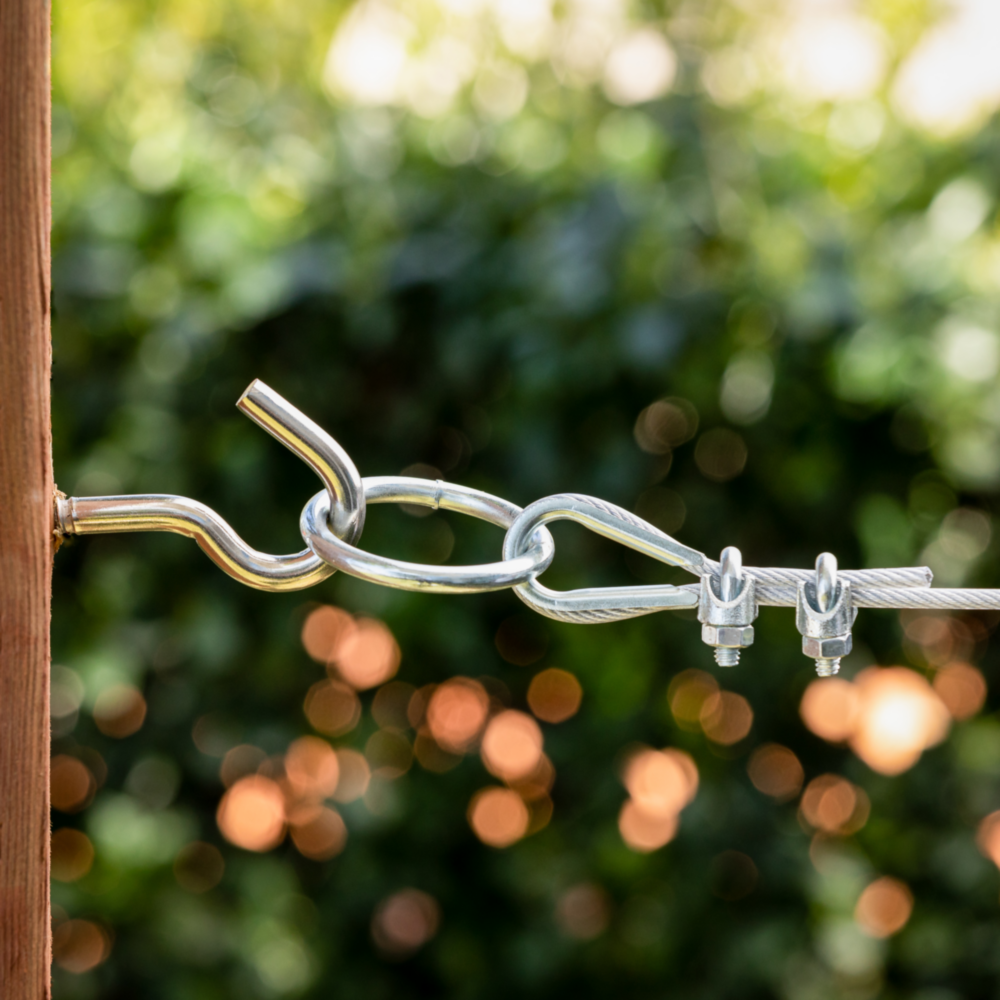 Stainless steel hook bolt connected to cable clamps on wire rope for outdoor hardware and home improvement projects