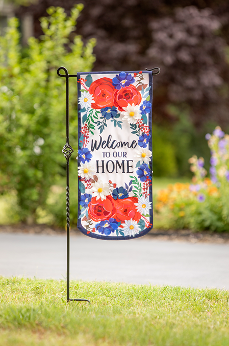 Garden flag with bright red, white, and blue floral design and welcoming home message for outdoor living decor