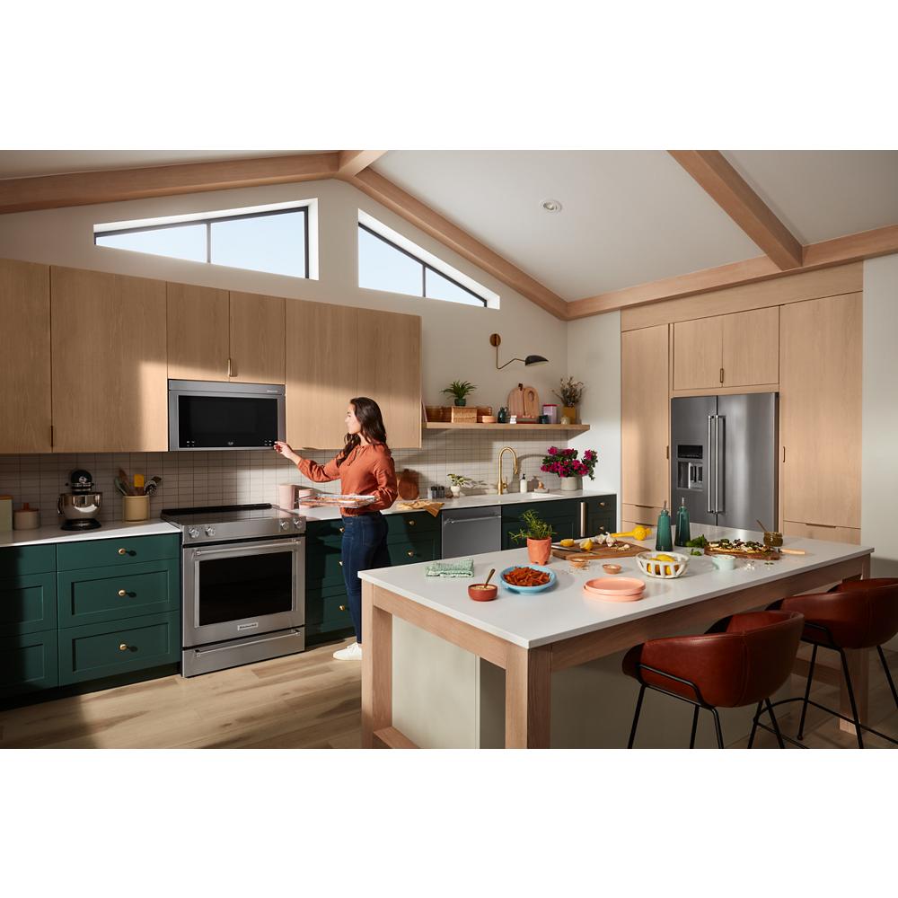 Modern kitchen with green lower cabinets and wood upper cabinetry featuring a stainless multifunction over-the-range oven