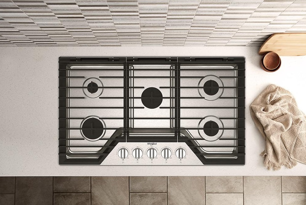 Black five-burner gas cooktop with EZ-2-Lift cast-iron grates and stainless steel control panel on kitchen countertop