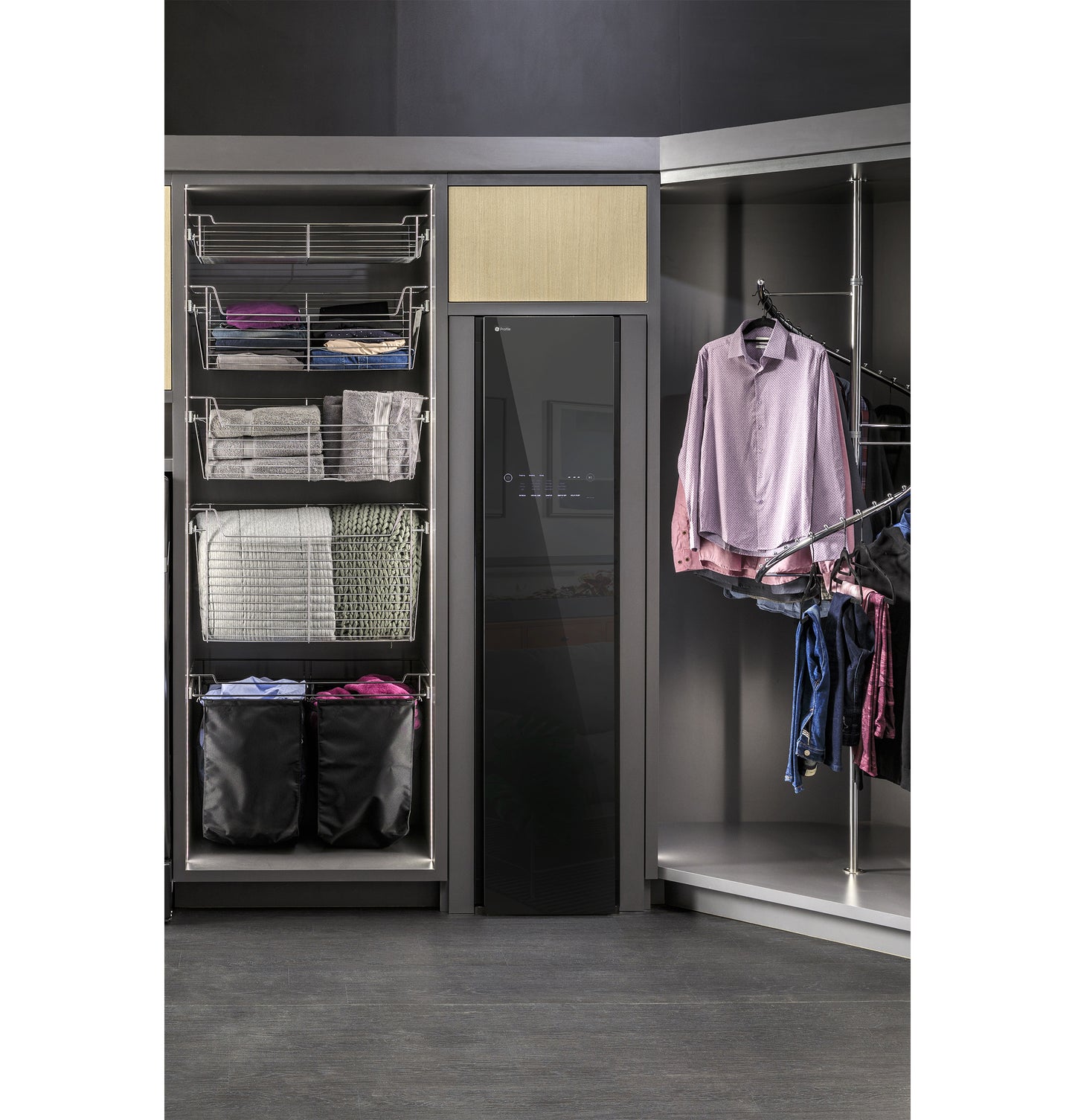 Sleek black steam closet with fabric refresh next to organized open closet shelving and hanging clothes in laundry area