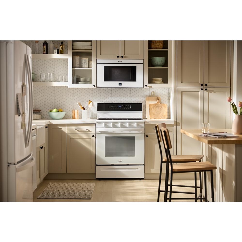 Modern kitchen with beige cabinetry featuring a white smart gas range and built-in microwave from ranges collection