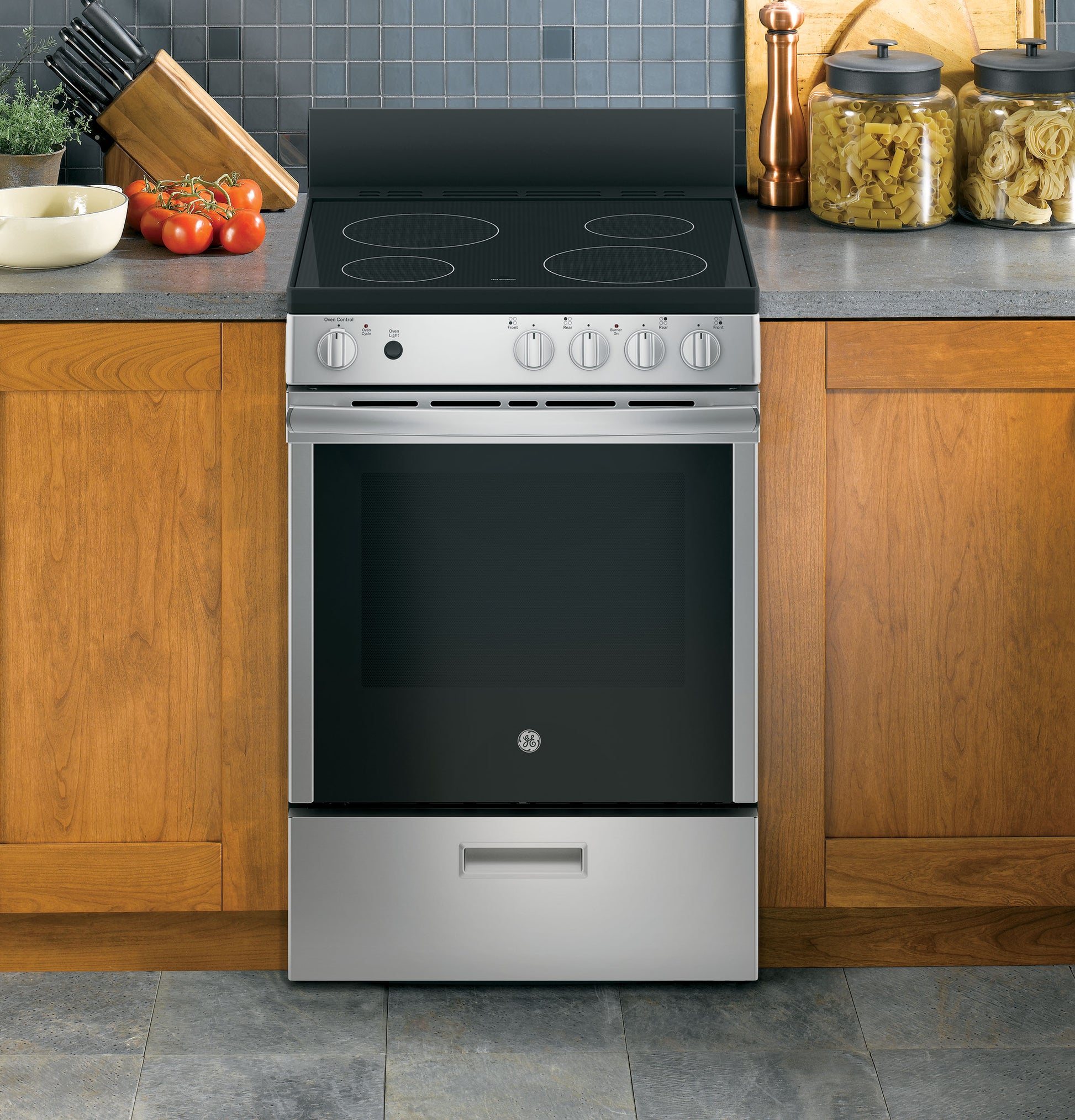 Stainless steel front control electric range with smooth black glass cooking surface in kitchen setting