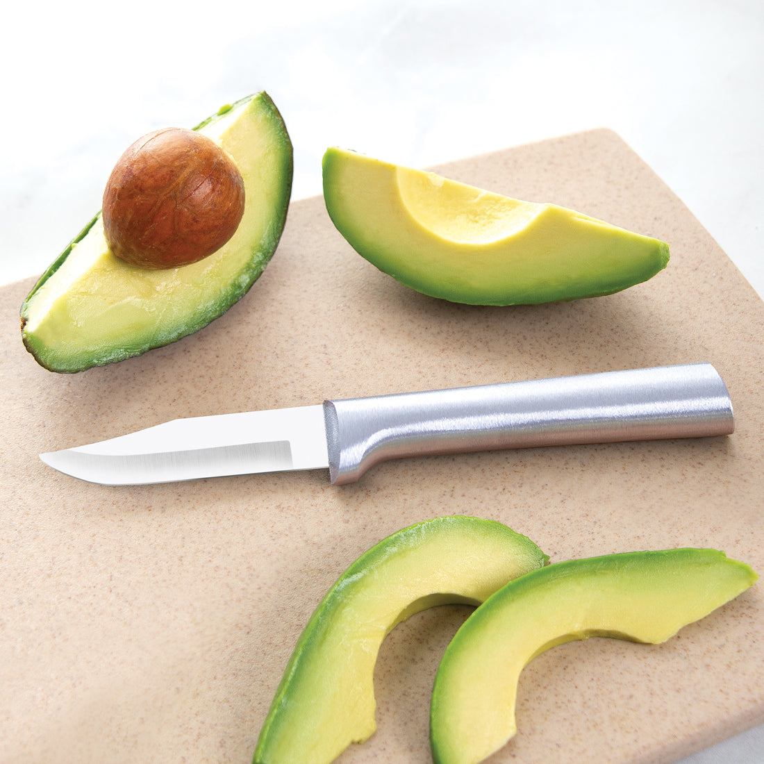 Sharp paring knife with metal handle slicing fresh avocado on cutting board in Kitchenware and Cooking Utensils collections