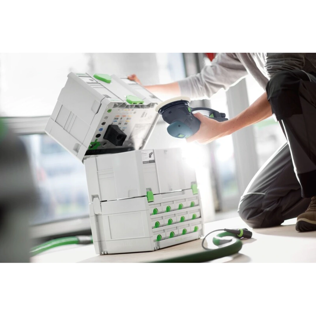 Person opening white and green multi-drawer Festool tool storage for workshop organization and woodworking tools