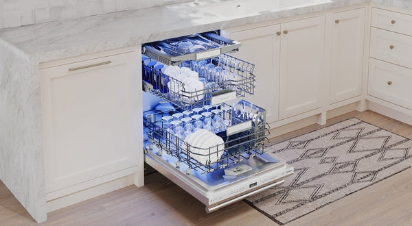 Open stainless steel dishwasher with illuminated racks fully loaded with dishes in a modern kitchen setting