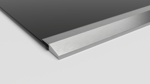 Close-up of a stainless steel framed edge on a black surface-mount electric cooktop from Bosch kitchen appliances collection