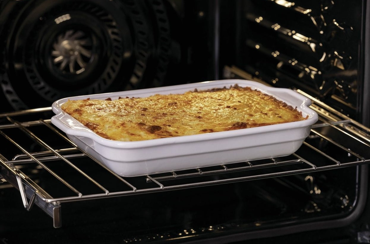 Casserole baking inside an electric wall oven featuring convection fan for even cooking in kitchen appliance setting