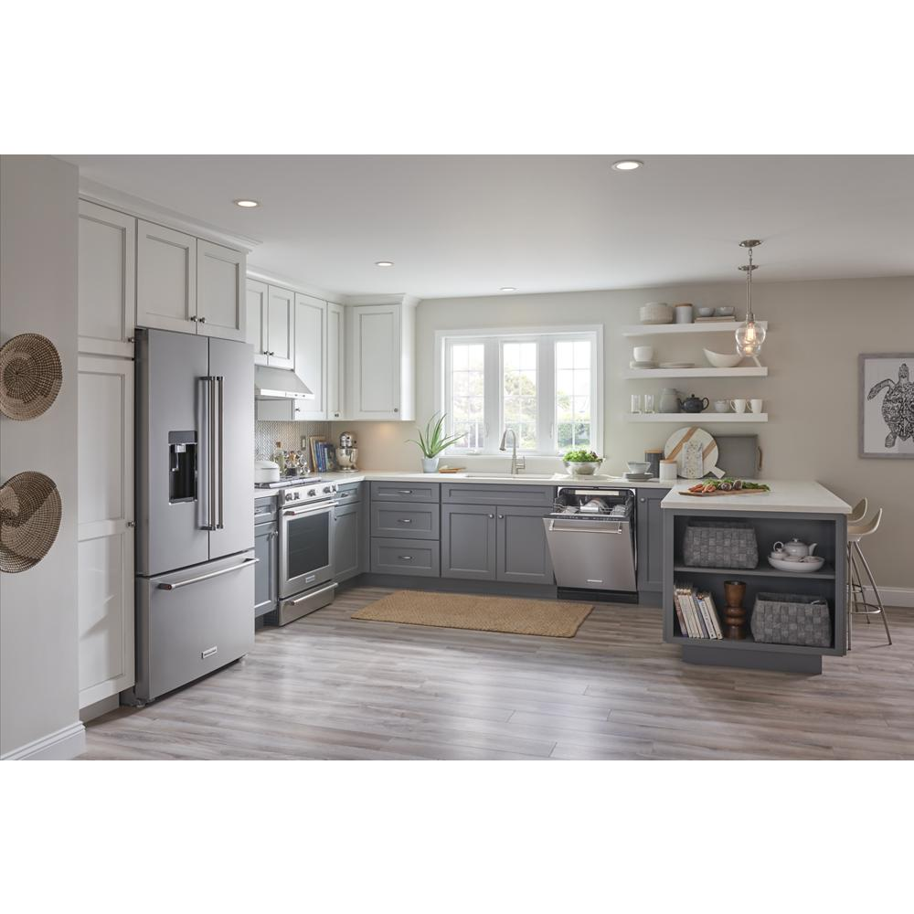 Spacious kitchen with gray lower cabinets, white upper cabinetry, stainless steel appliances, and open shelving with décor