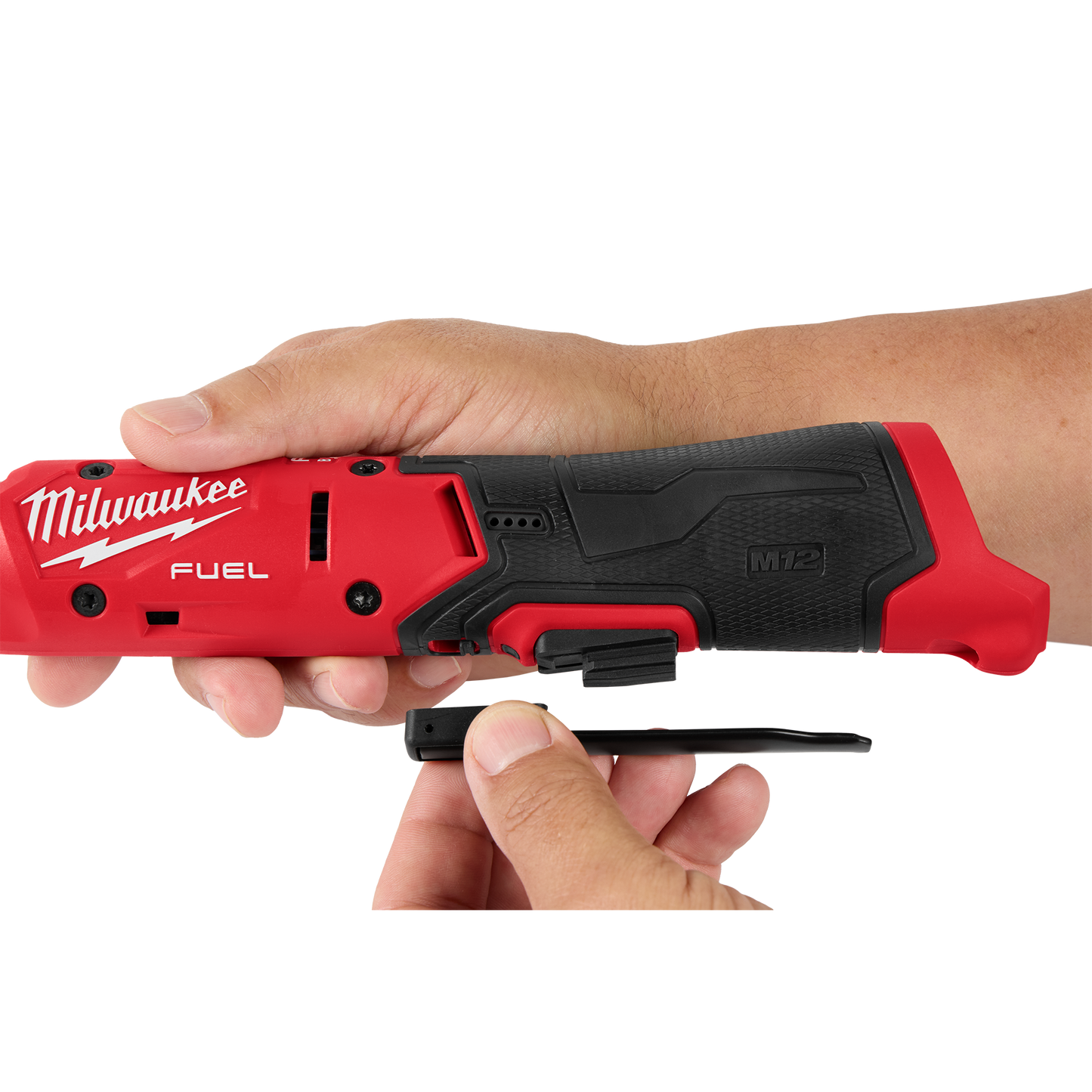 Close-up of hands attaching a black belt clip to a red and black Milwaukee M12 FUEL™ cordless ratchet, part of Sockets & Ratchets and Hand Tools at Hartville Hardware.