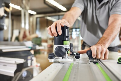 Person adjusting a Festool guide rail system for precise woodworking in power and woodworking tool accessories collections