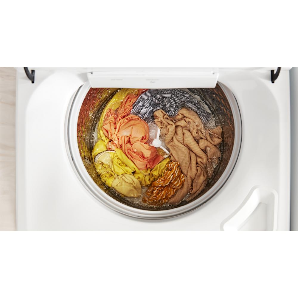 Top view of a top-loading washer with assorted colorful clothes inside the stainless steel drum in home appliances collection