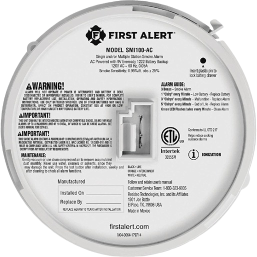 Back view of a white ionization smoke alarm with warning labels, battery compartment, and installation instructions