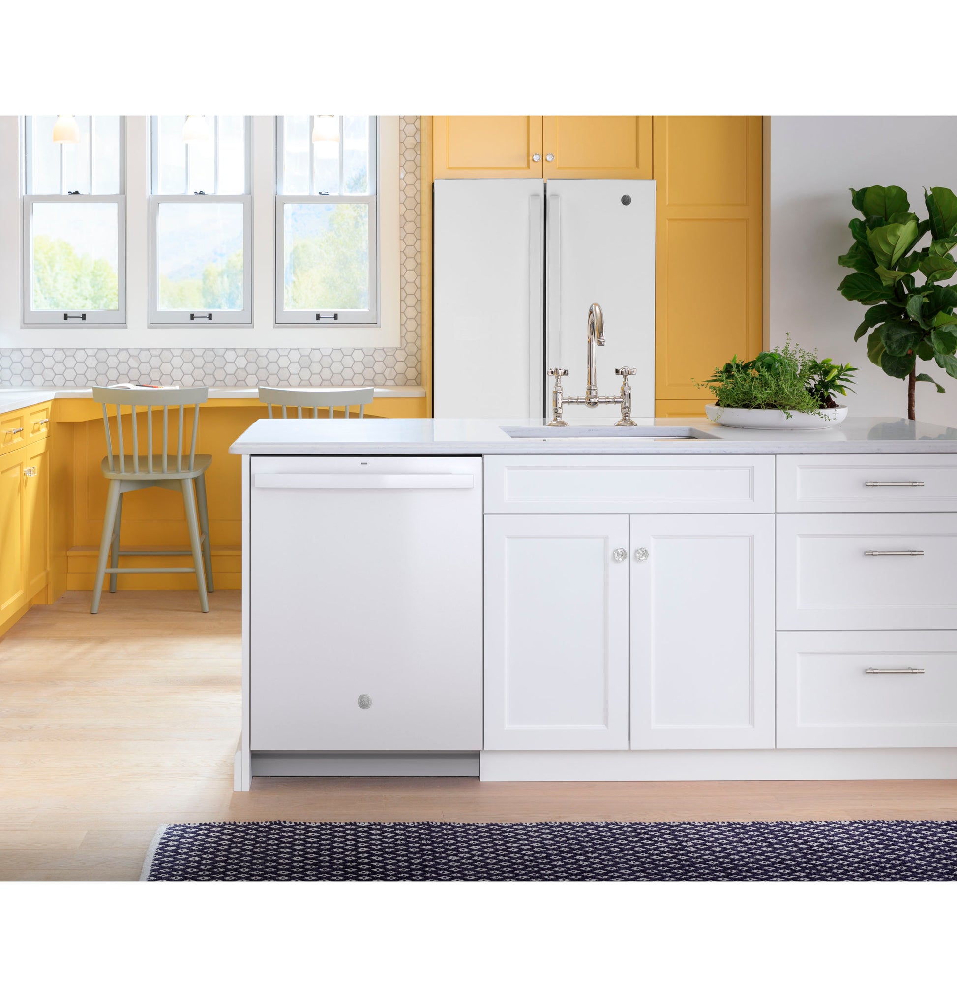 White top control dishwasher integrated into bright kitchen island with yellow cabinetry and modern stainless faucet in appliances collection